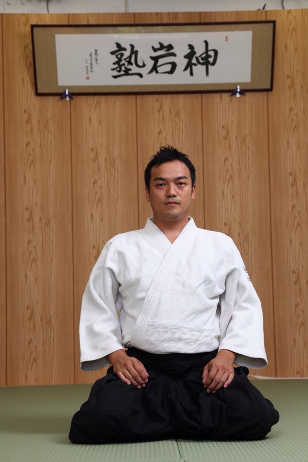 扁額を背に正座する塾長 樋口龍馬